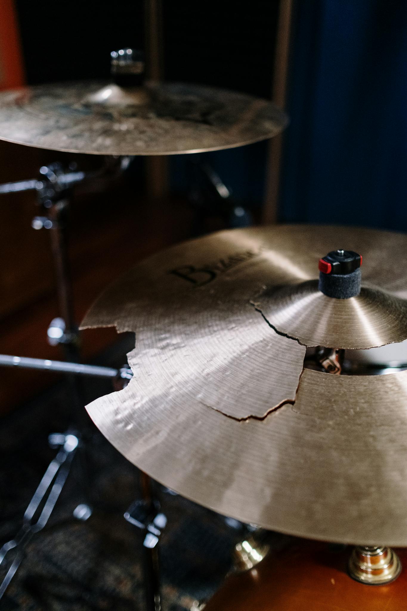 Detailed look at a broken cymbal on a drum set, showcasing wear and tear.